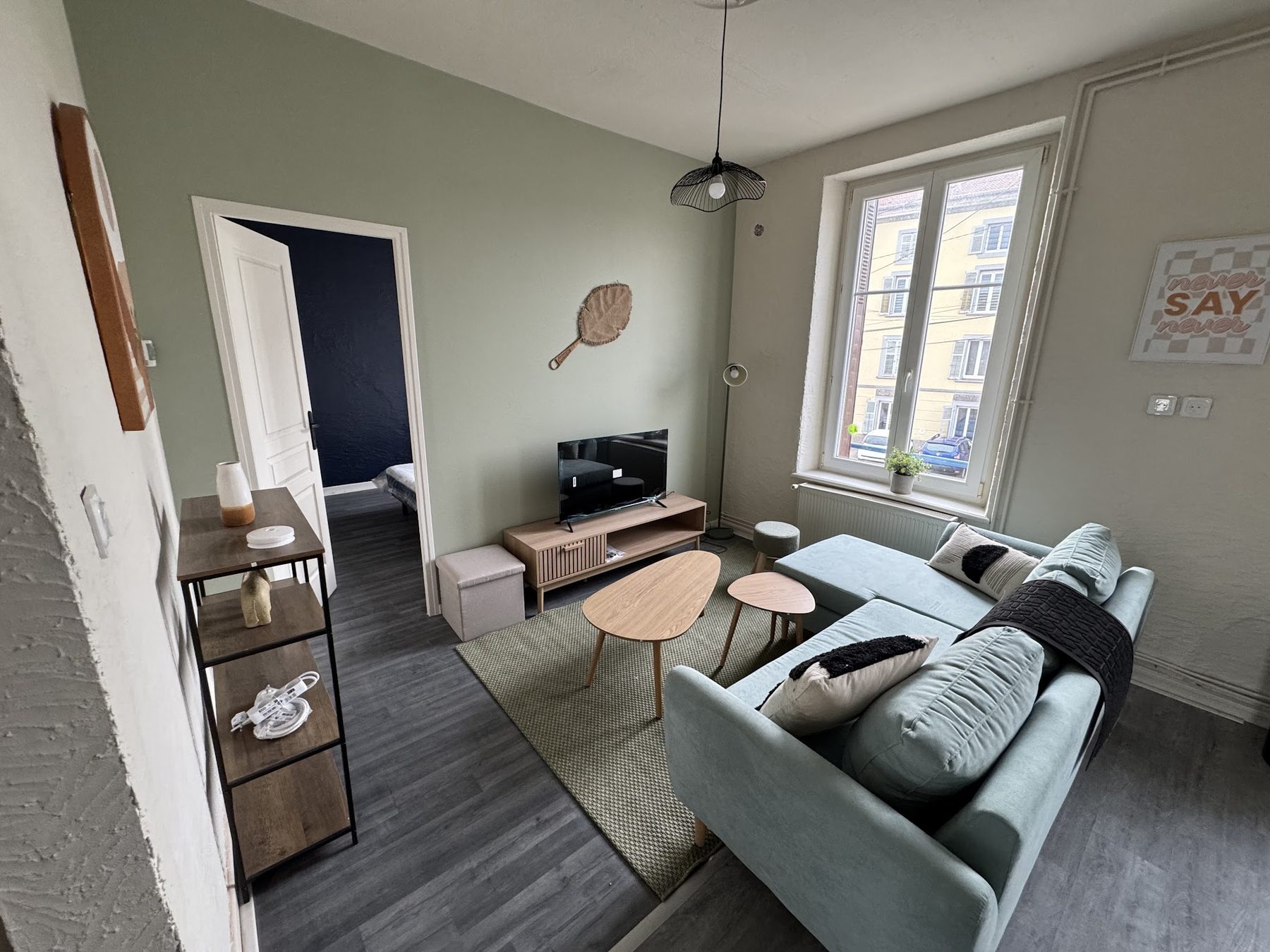 Séjour vert sauge, porte sur une chambre bleu nuit