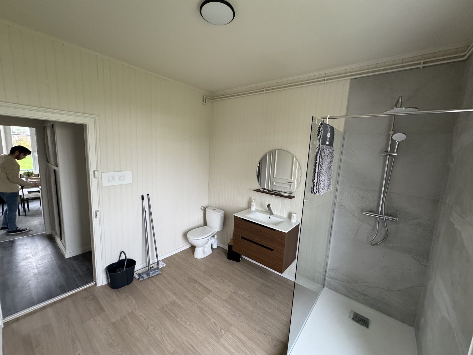 Salle d'eau avec lambris blanc et douche à l'italienne